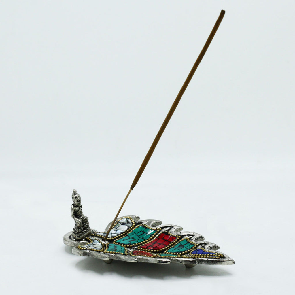 Decorative incense holder with colorful design on a white background