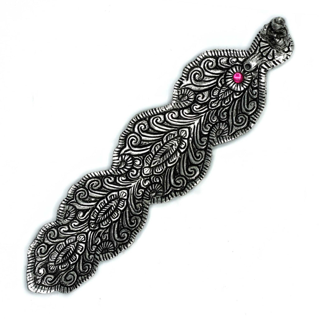 Decorative silver snake-shaped object with a pink gem on a white background