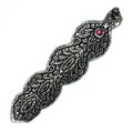 Decorative silver snake-shaped object with a pink gem on a white background
