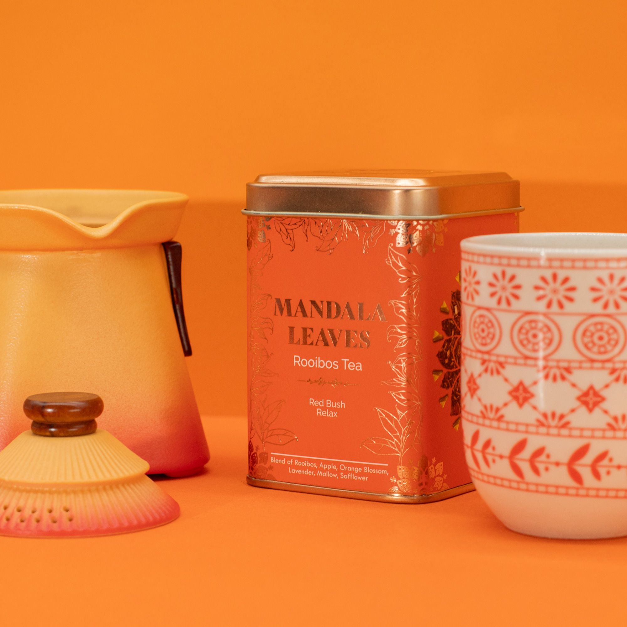 Tea canister and mug with mandala design on an orange background