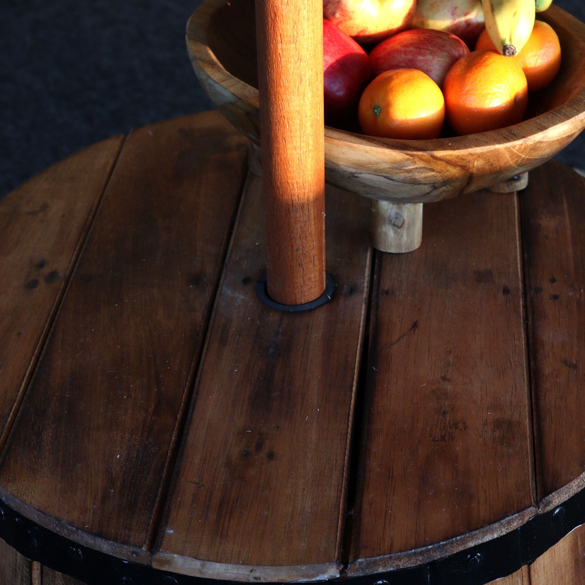Wooden bowl with fruits on a wooden barrel