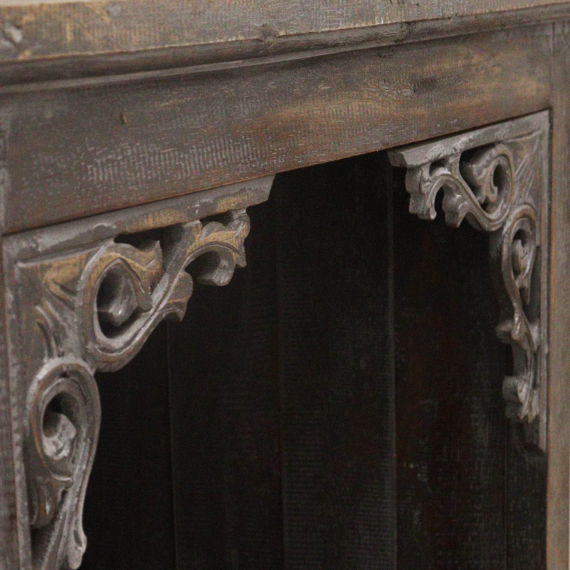 Decorative fireplace with ornate metalwork on a dark background