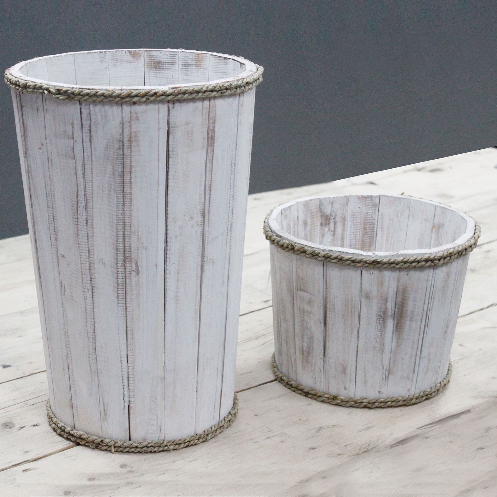 Two wooden planters with a rustic finish on a wooden surface.