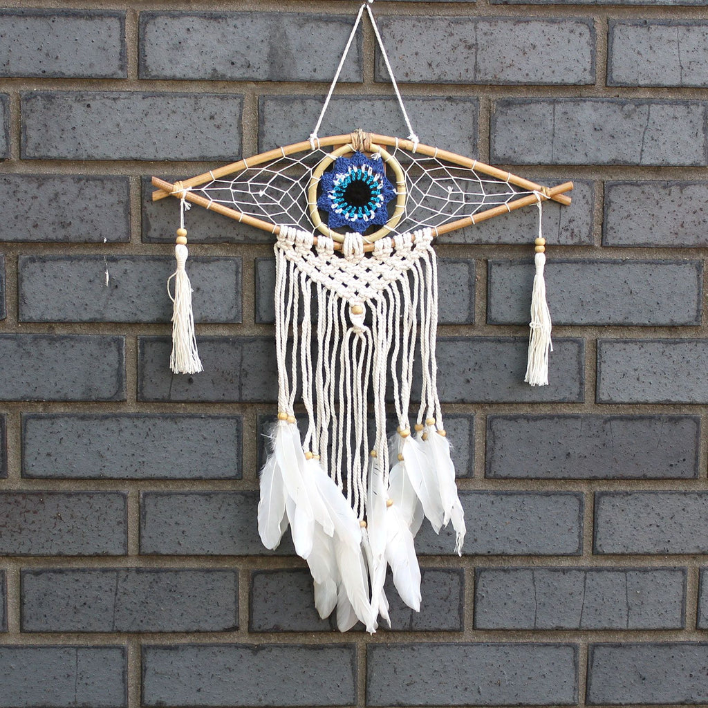 Dreamcatcher with feathers hanging on a brick wall