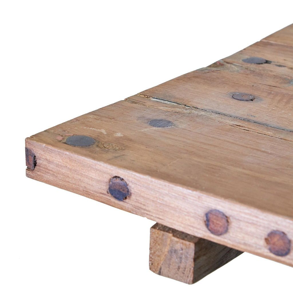Close-up of a wooden bench with visible grain and knots on a white background