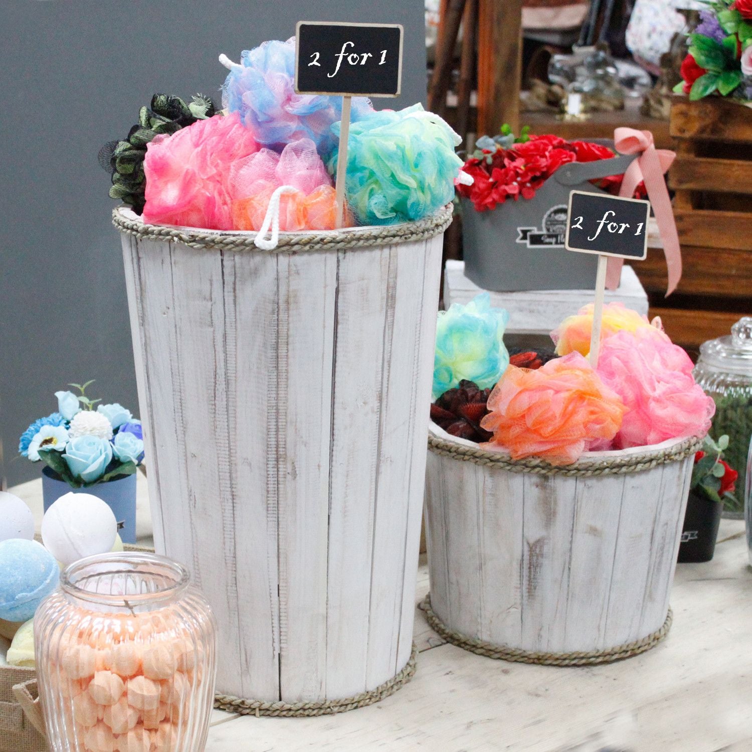 Decorative items including colorful pom-poms in metal buckets on a table.