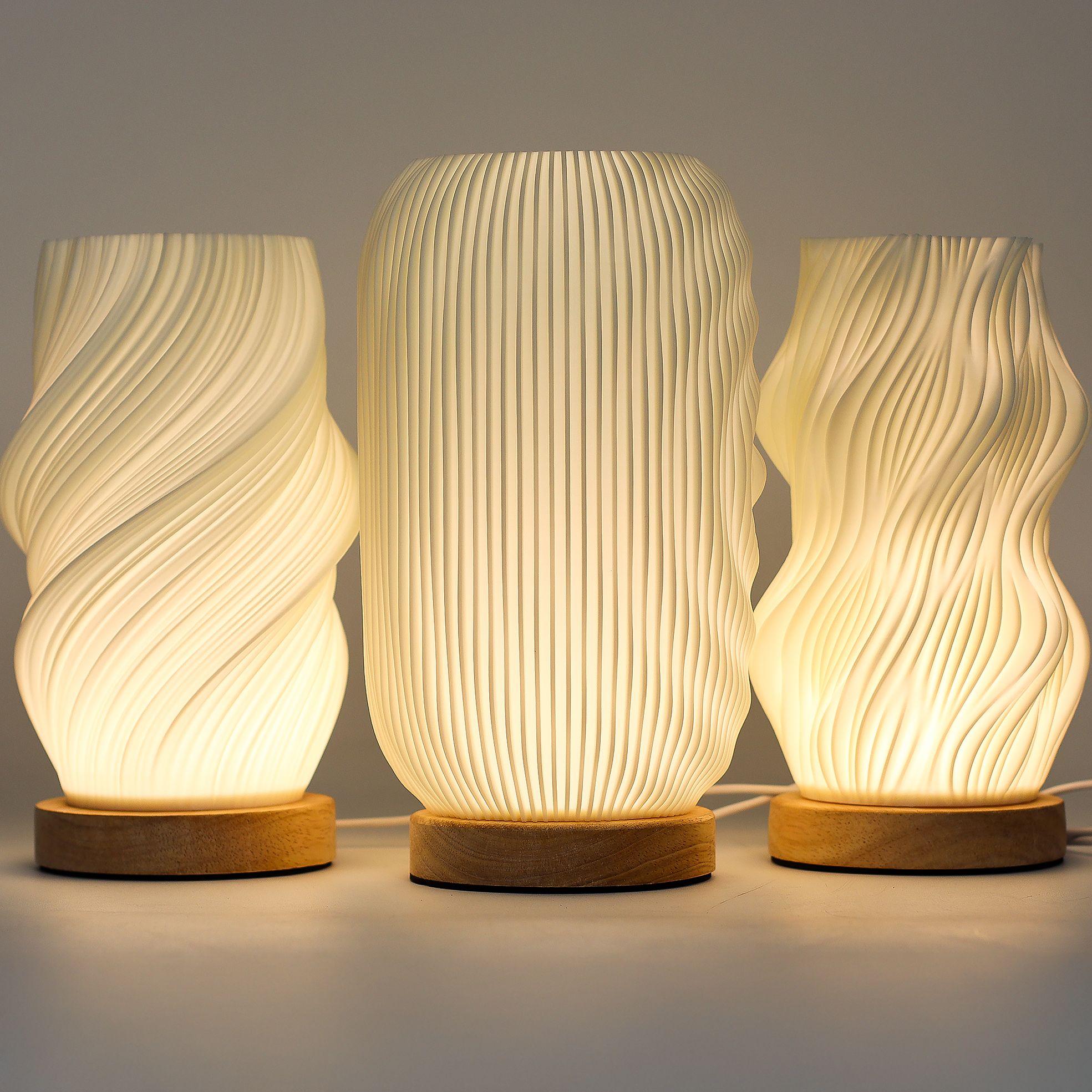 Three textured table lamps with wooden bases on a neutral background