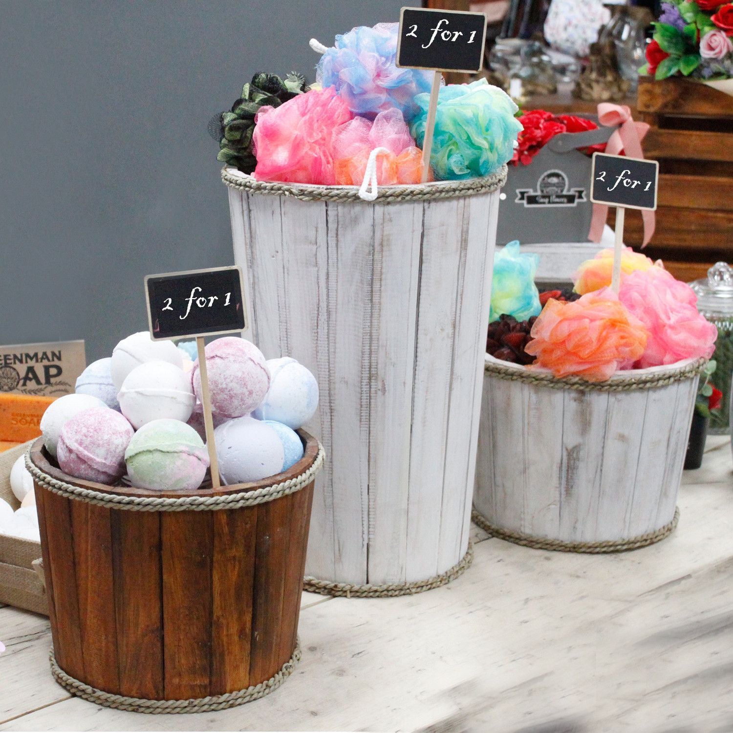 Three decorative pots with colorful bath bombs on a table.