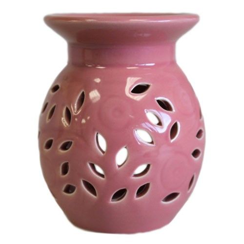Pink ceramic oil burner with holes on a white background