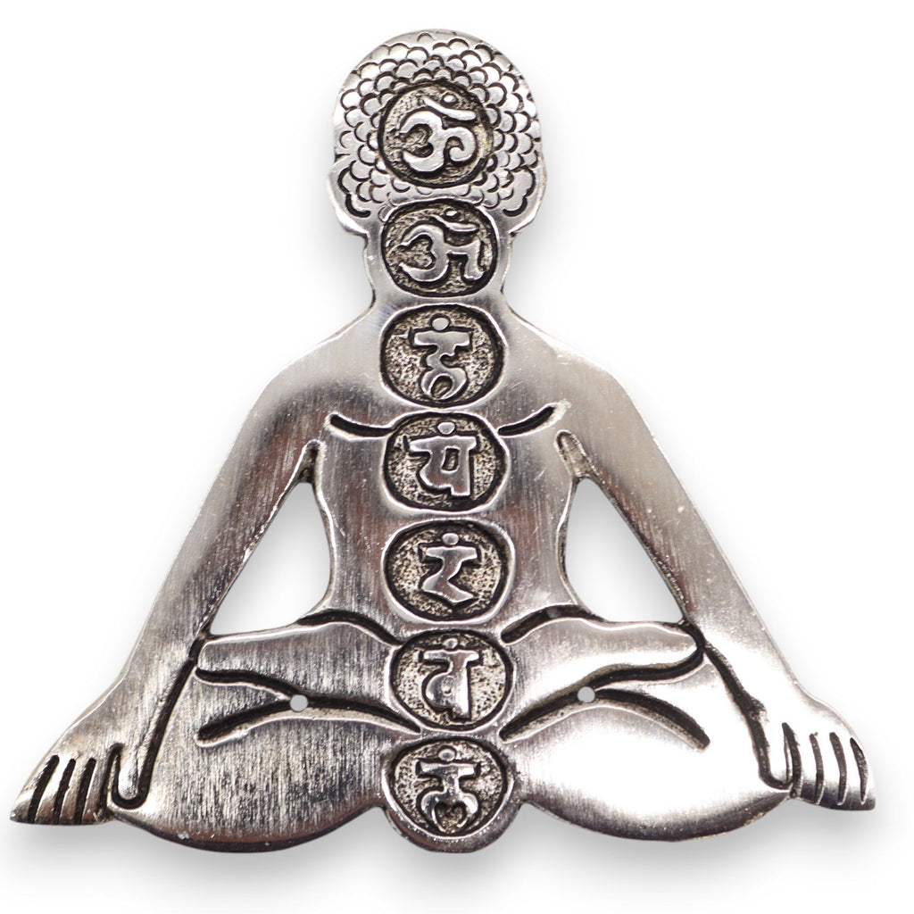 Silver pendant of a meditating figure with symbols on a white background