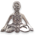 Silver pendant of a meditating figure with symbols on a white background