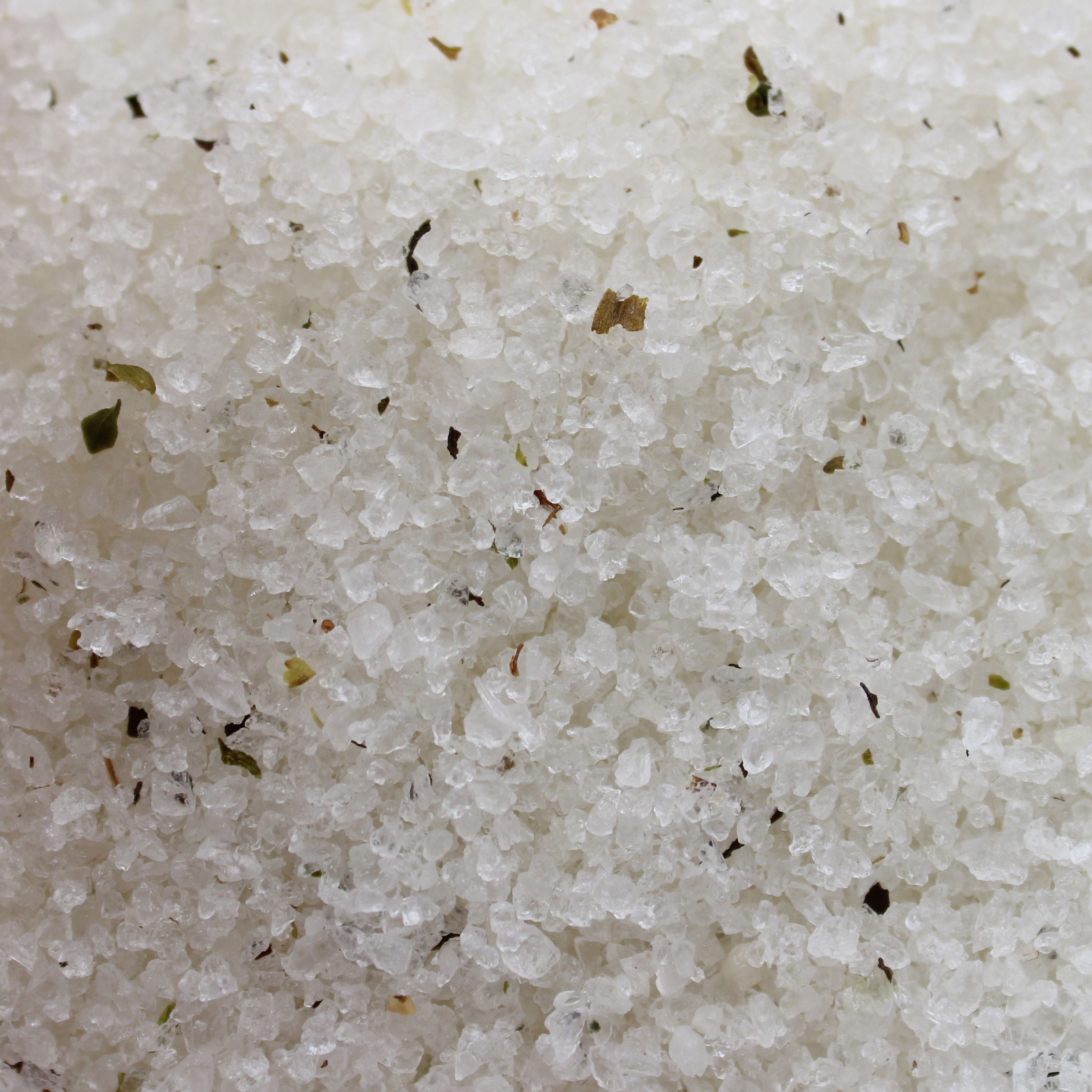 Close-up of white sand with small particles and bits of debris.