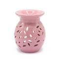 Pink ceramic oil burner with a white background