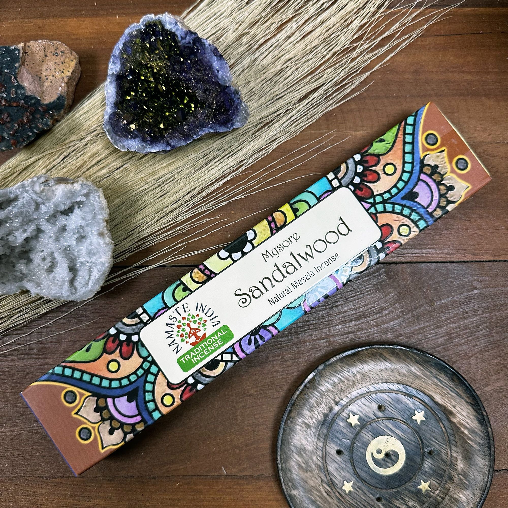 Colorful sandalwood incense box on a wooden surface with decorative elements.