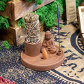 Incense burner with Buddha figure and incense sticks on a decorative rug