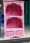 Pink wooden cabinet with intricate carvings on a white background