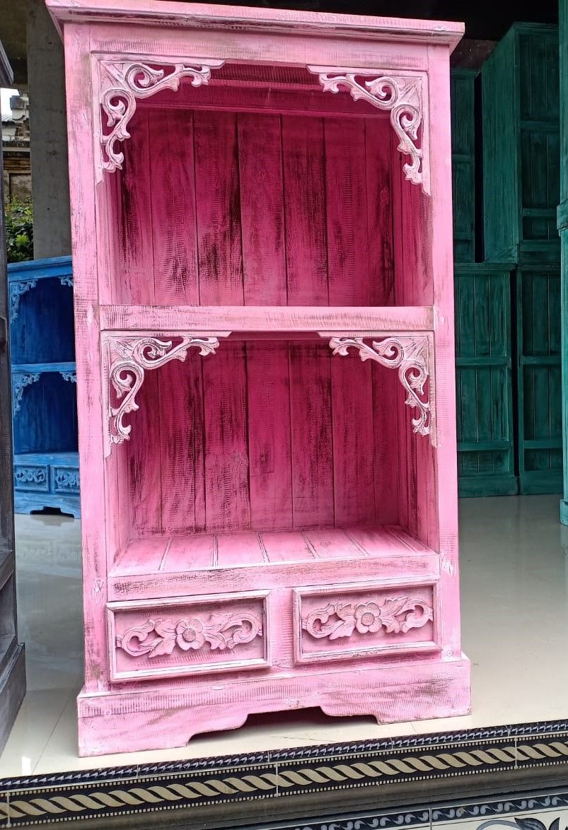 Pink wooden cabinet with intricate carvings on a white background