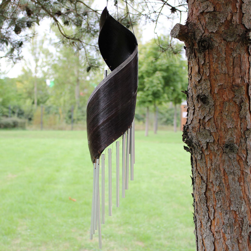 Decorative wind chime hanging from a tree in an outdoor setting