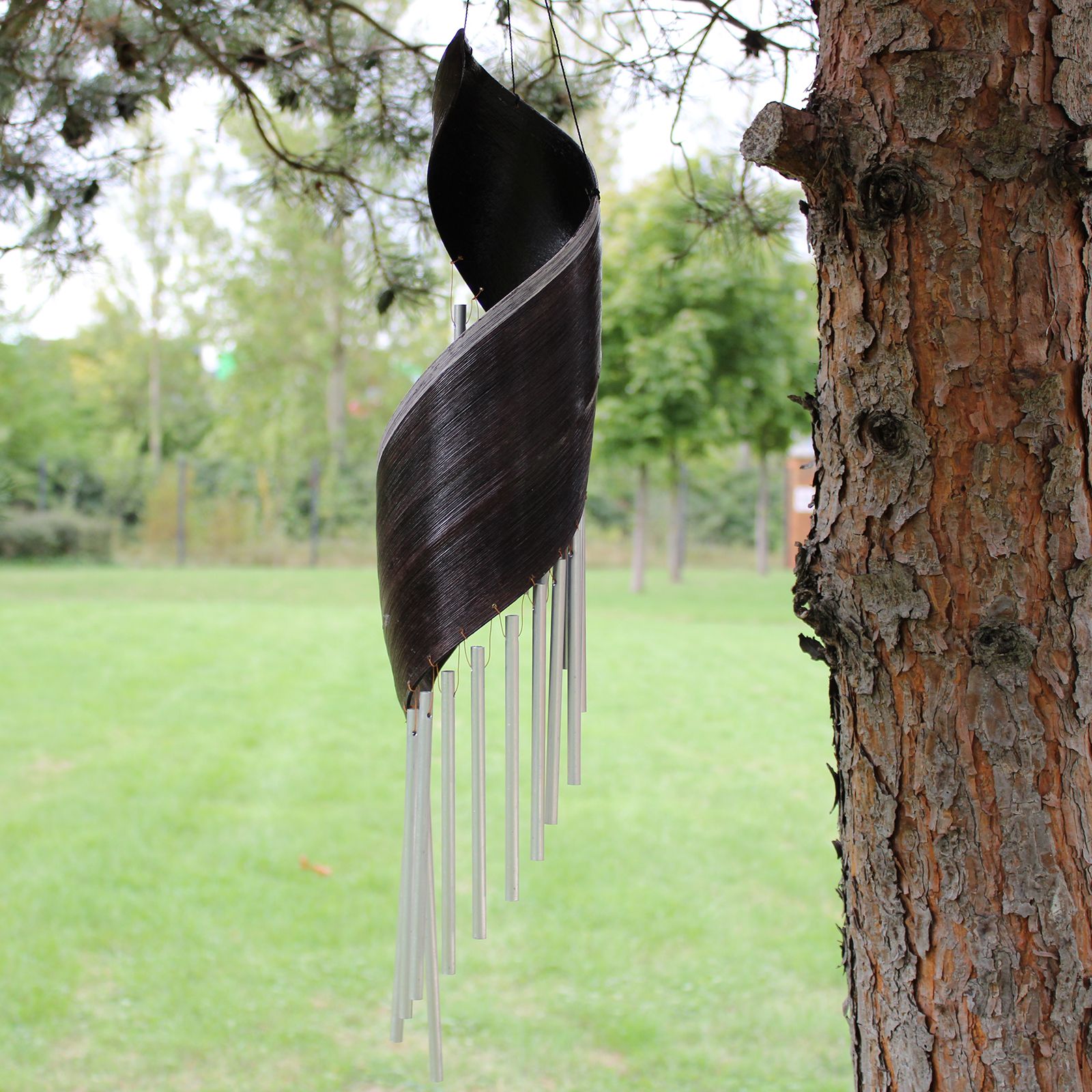Decorative wind chime hanging from a tree in an outdoor setting