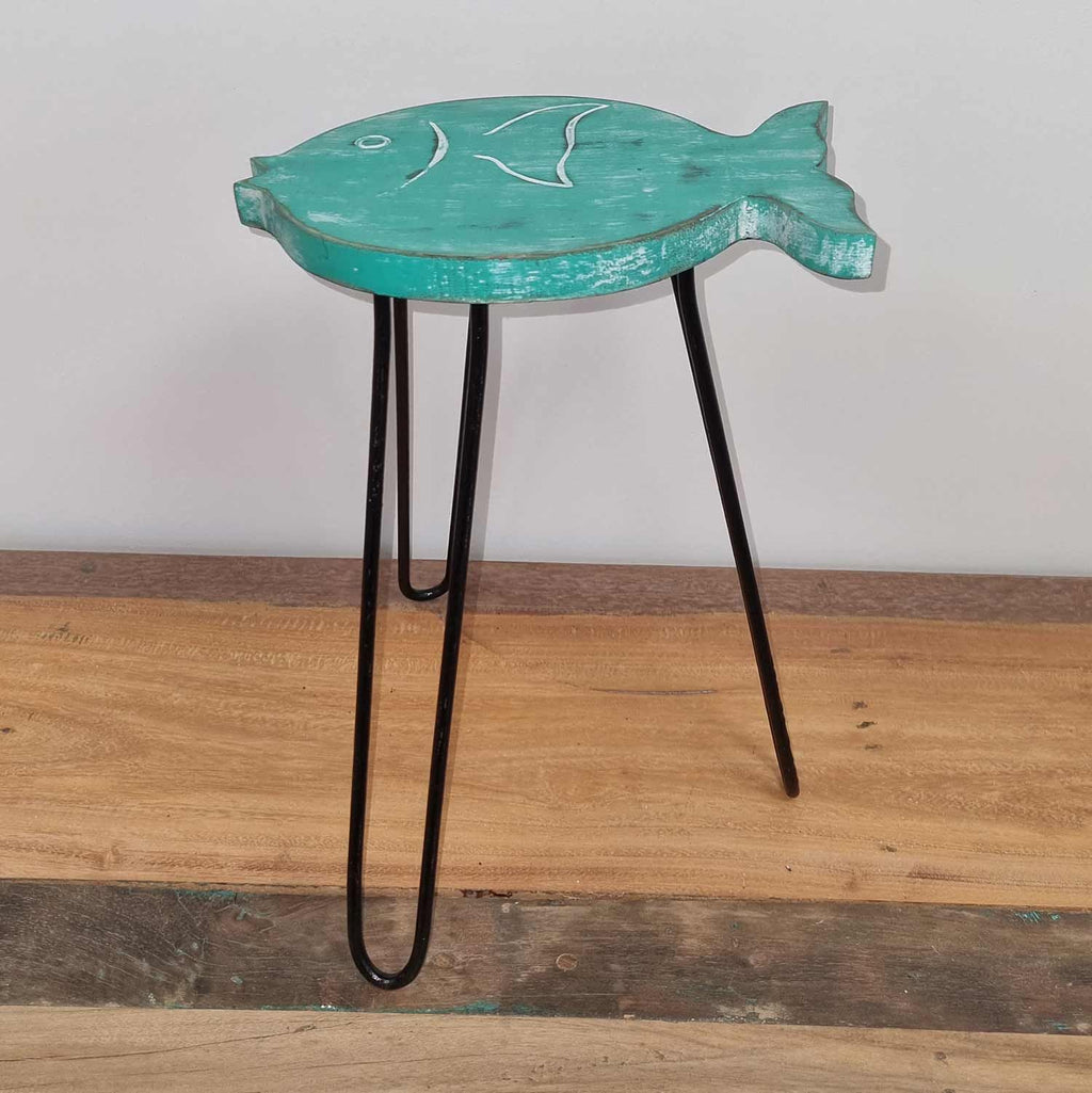 Fish-shaped side table with black hairpin legs on a wooden floor.