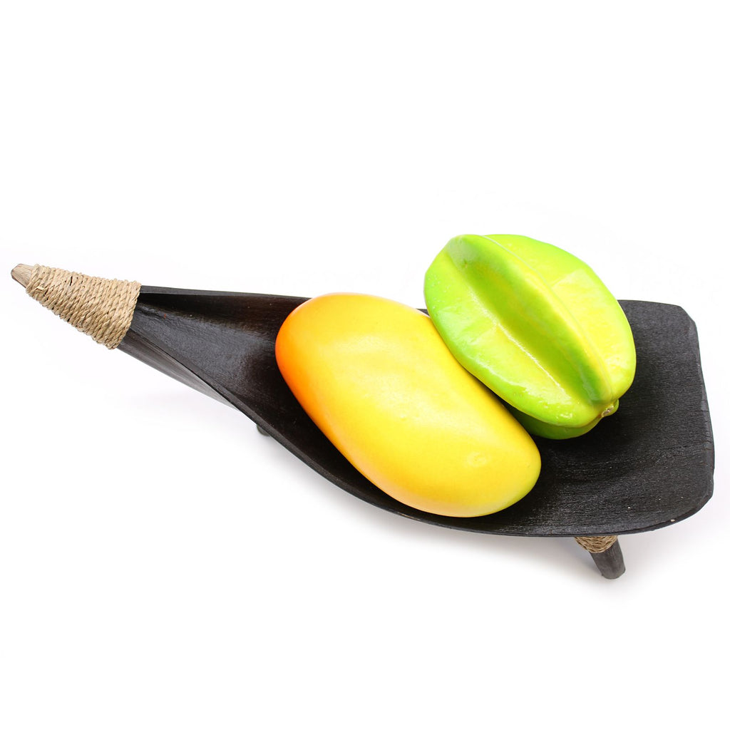 Two star fruits on a black leaf-shaped plate with a white background