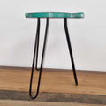 Small stool with a teal seat and black metal legs on a wooden floor.