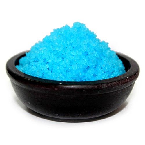 Black bowl filled with blue sand on a white background