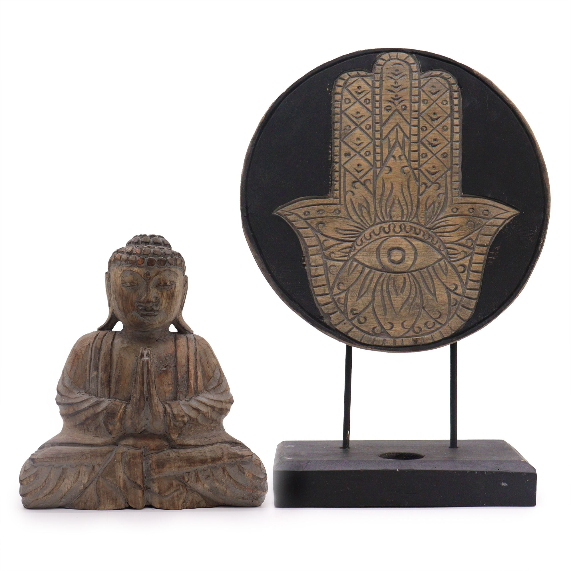 Wooden Buddha statue and Hamsa hand symbol on a stand against a white background