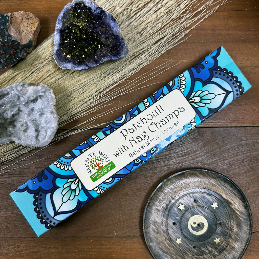 Incense stick packaging with decorative design on a wooden surface with natural elements.