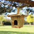 Wooden birdhouse hanging from a tree branch with a blurred natural background