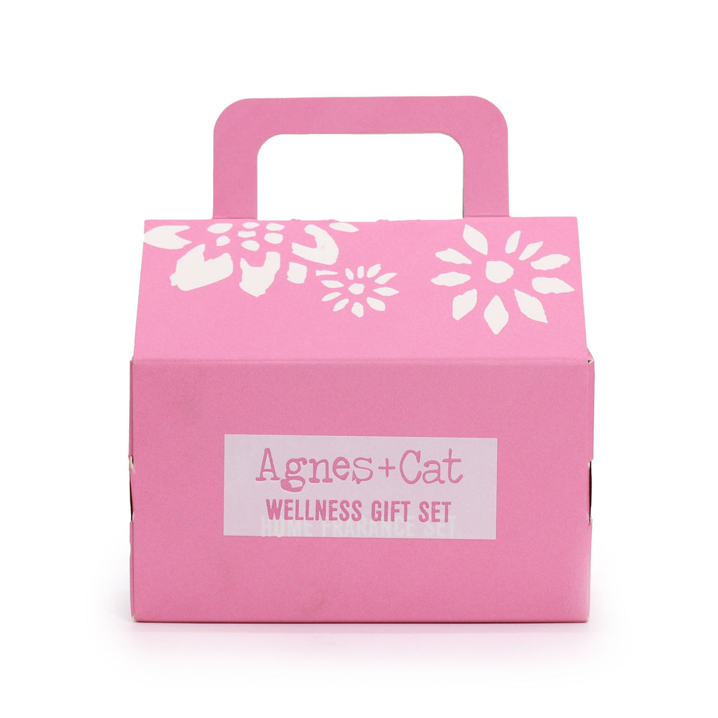 Pink gift box with white floral designs and 'Agnes + Cat Wellness Gift Set' label on a white background