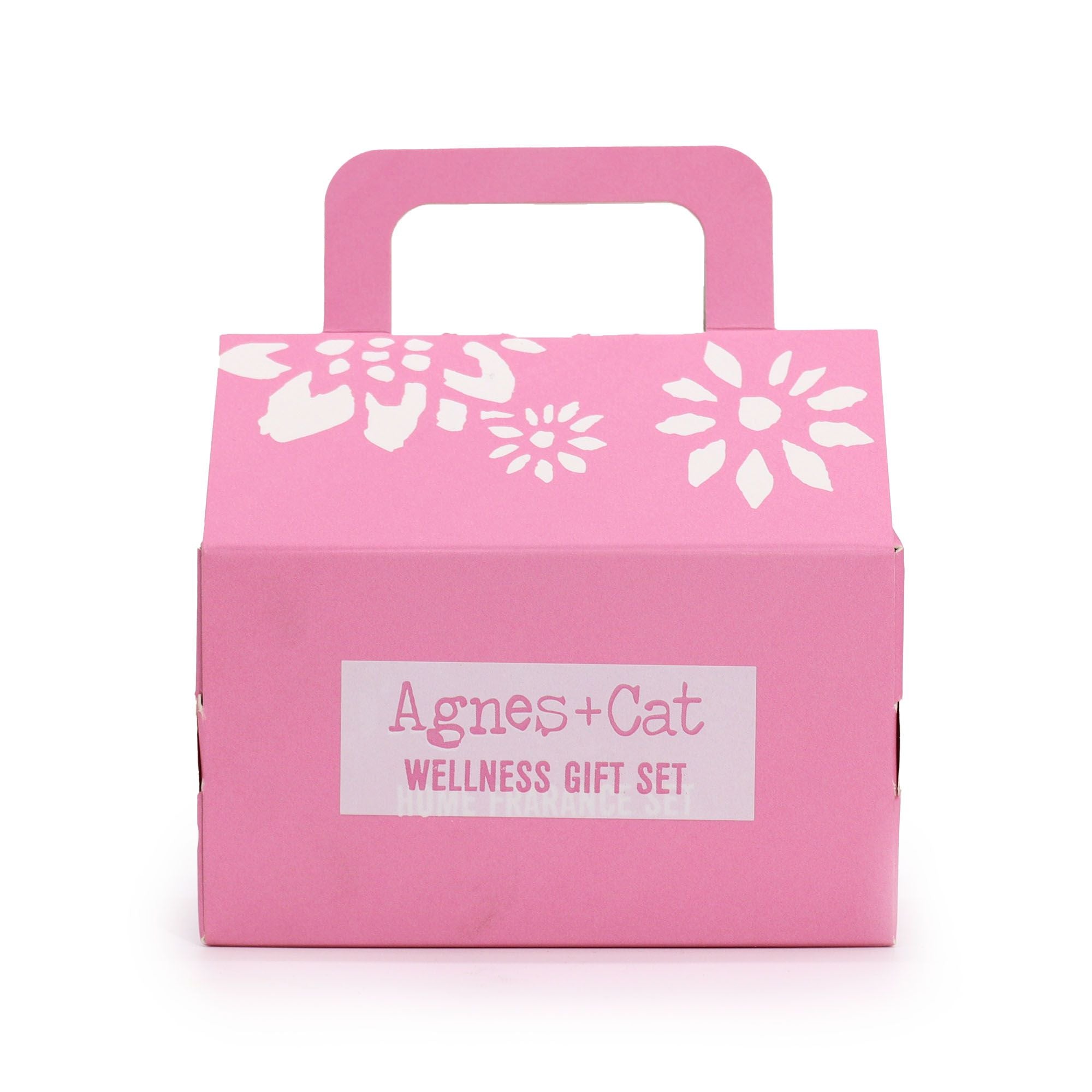 Pink gift box with white floral designs and 'Agnes + Cat Wellness Gift Set' label on a white background