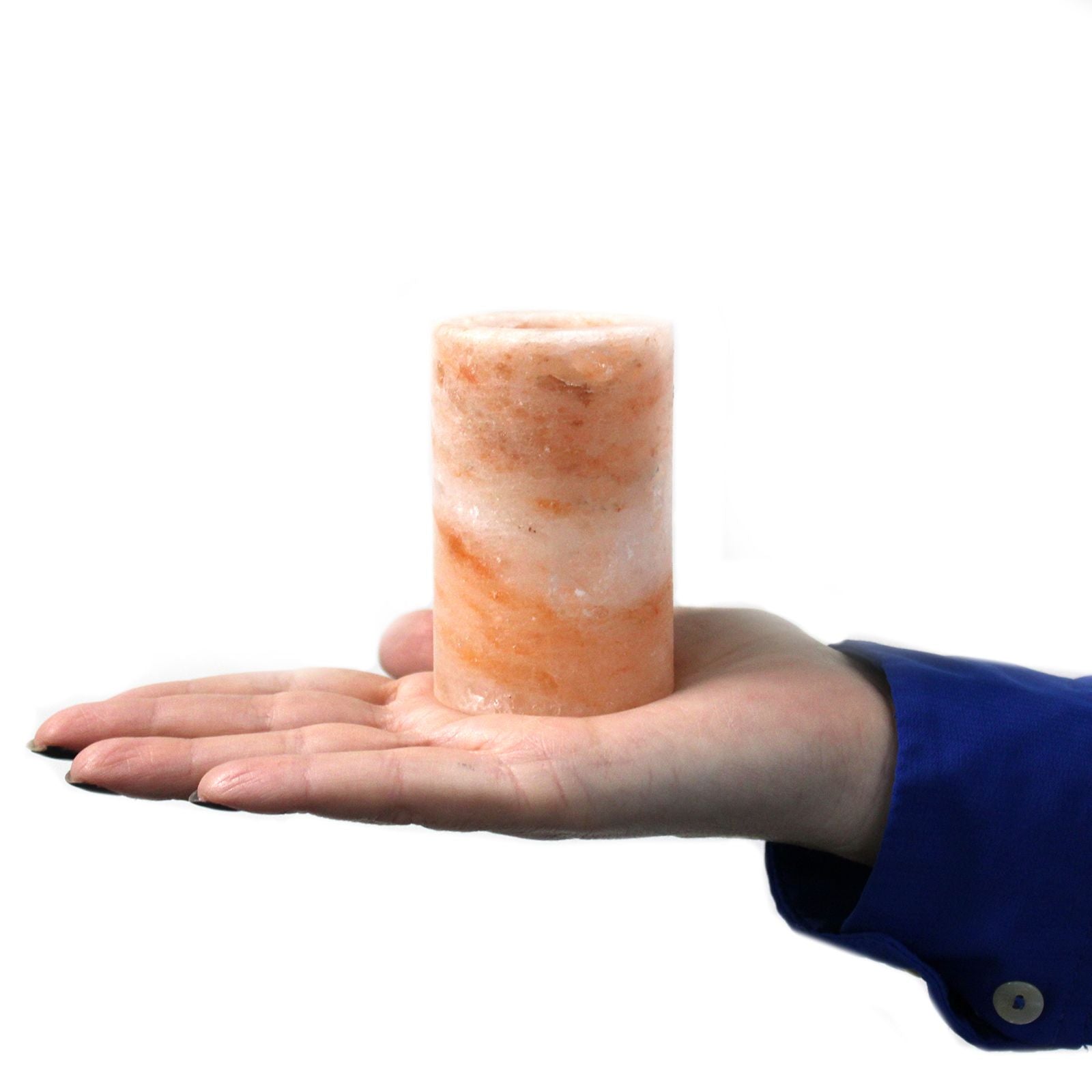 Himalayan salt lamp held in a hand against a white background