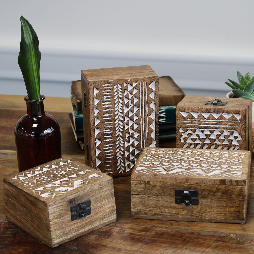 Set of wooden boxes with geometric patterns on a wooden surface.