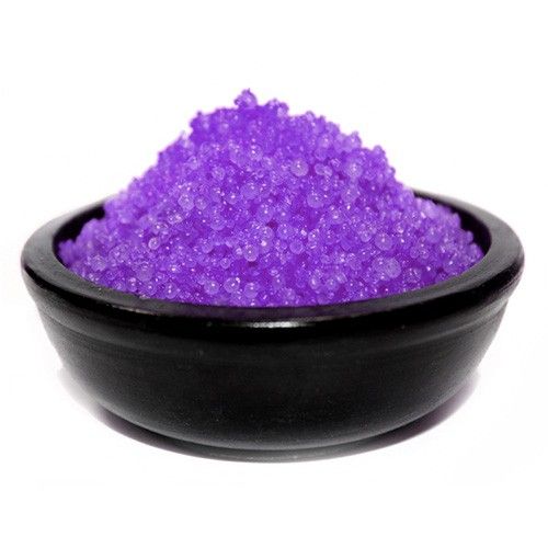 Purple granular substance in a black bowl on a white background