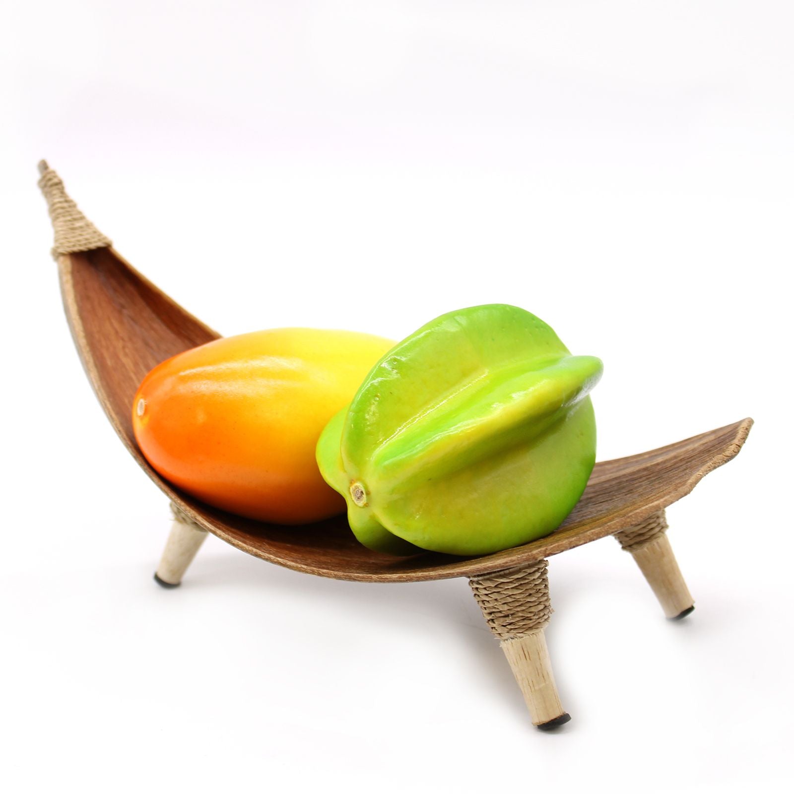 Two star fruits in a wooden boat-shaped holder on a white background