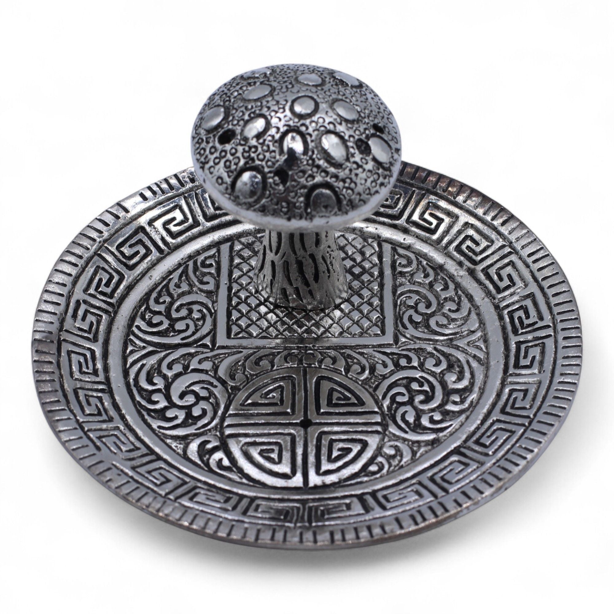 Decorative metal object with intricate patterns on a white background