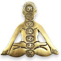 Bronze pendant of a meditating figure with symbols on a white background