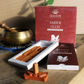 Ishom Amber Oudh incense sticks with packaging on a wooden surface