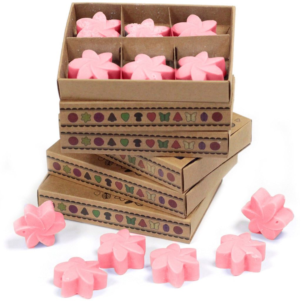 Pink flower-shaped candles in cardboard boxes with decorative patterns on a white background