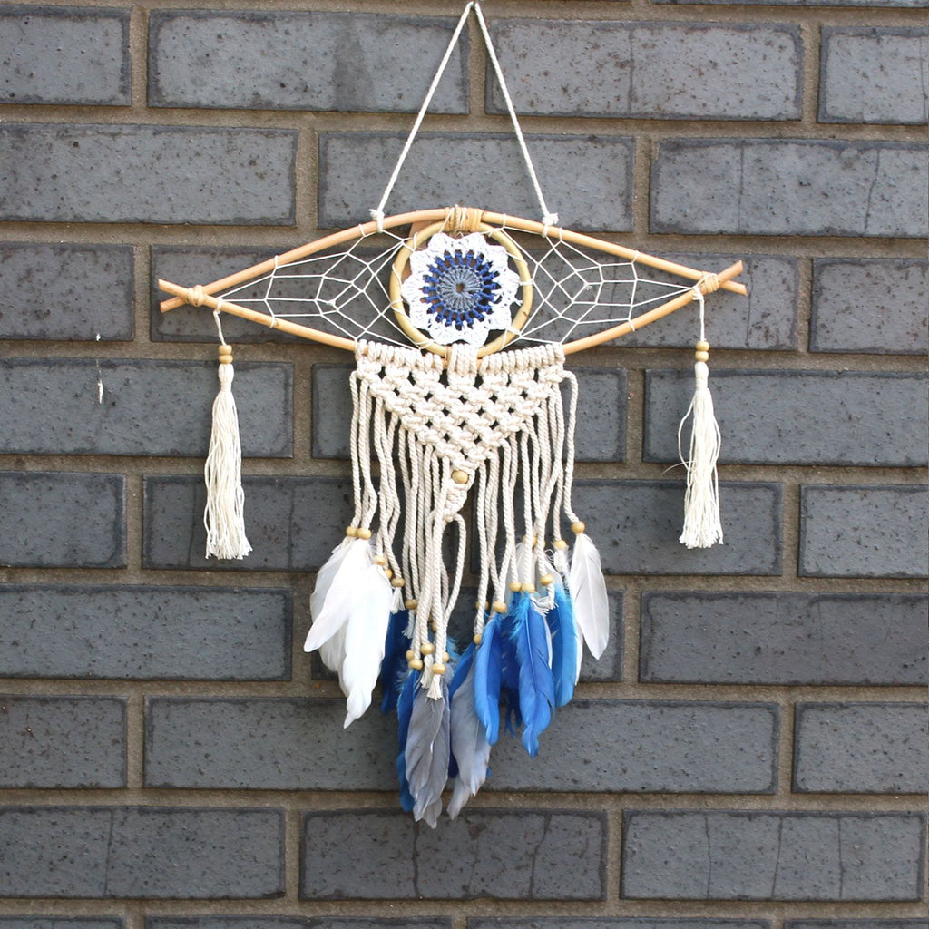 Dreamcatcher with feathers hanging on a brick wall