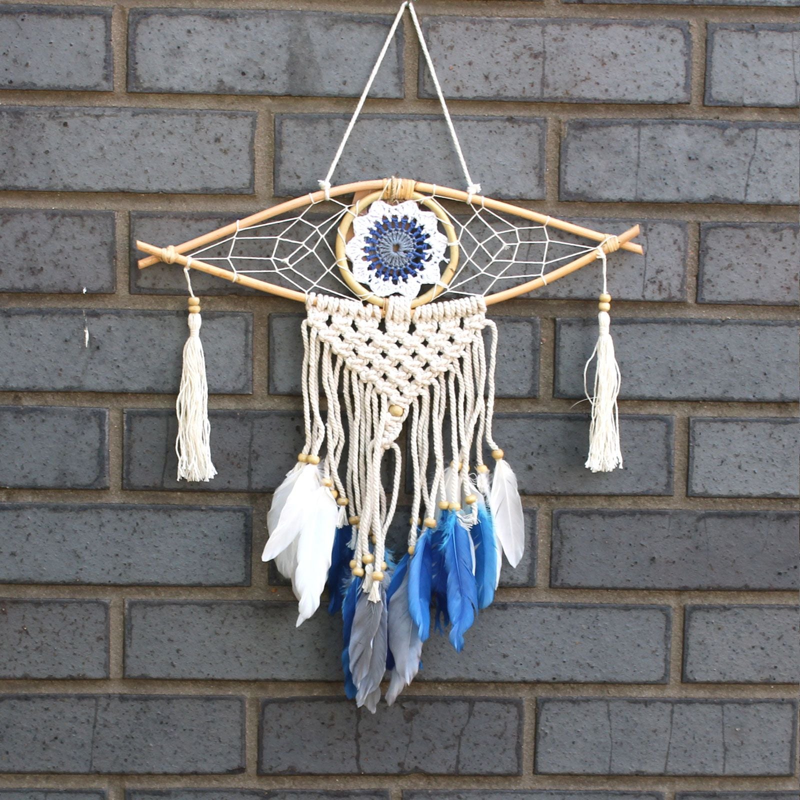 Dreamcatcher with feathers hanging on a brick wall