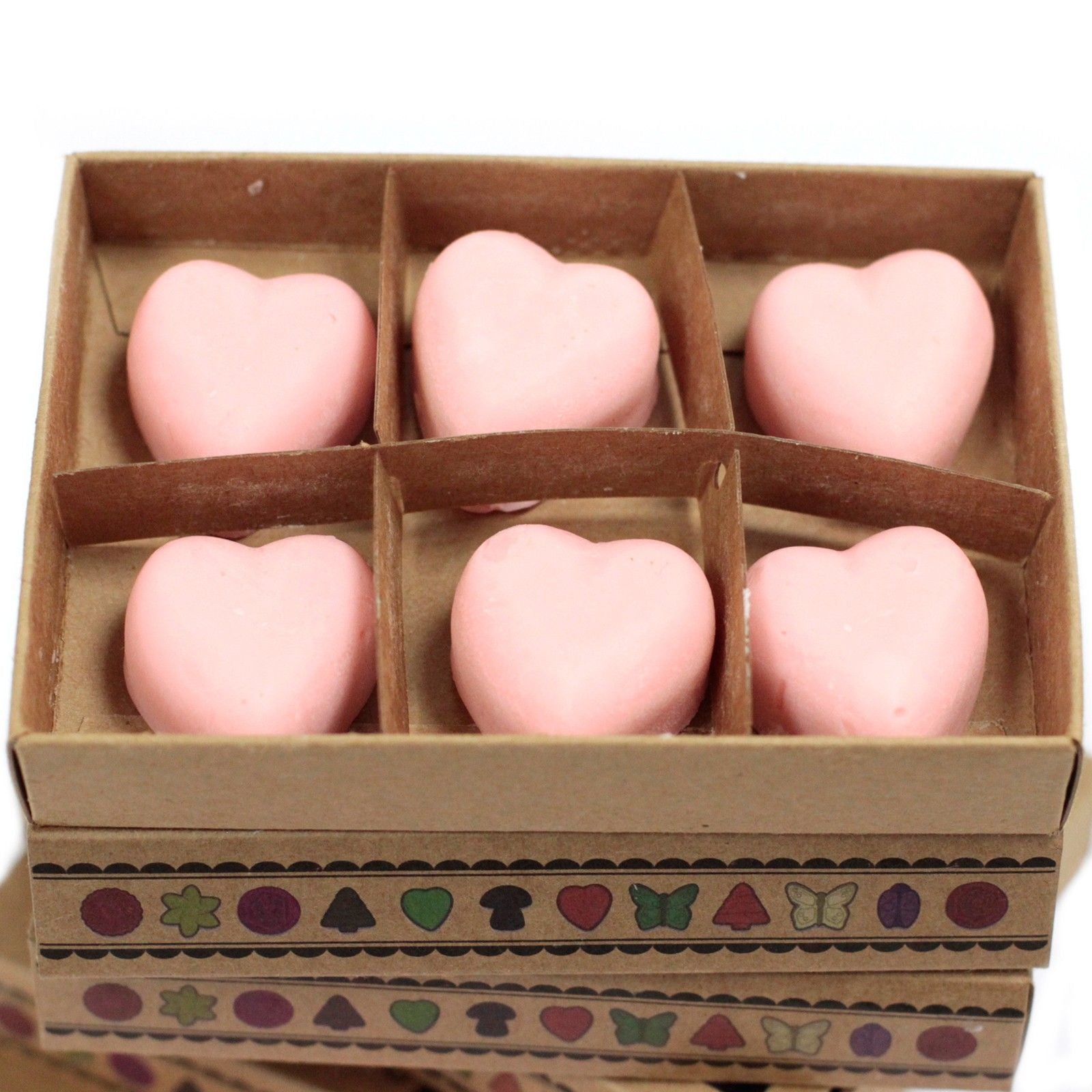 Heart-shaped pink objects in a decorative box with patterned border
