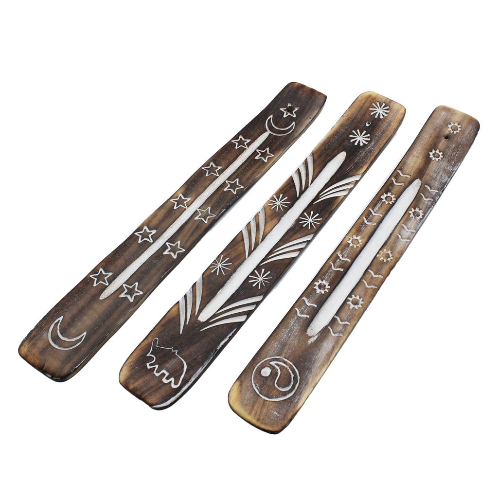 Set of wooden incense sticks with engraved designs on a white background