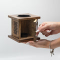Wooden square box with a hand opening it on a light gray background