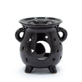 Black ceramic oil burner with star and moon design on a white background