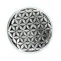 Circular metal object with a geometric flower pattern on a white background