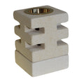 Cement-like square candle holder with a brass center on a white background