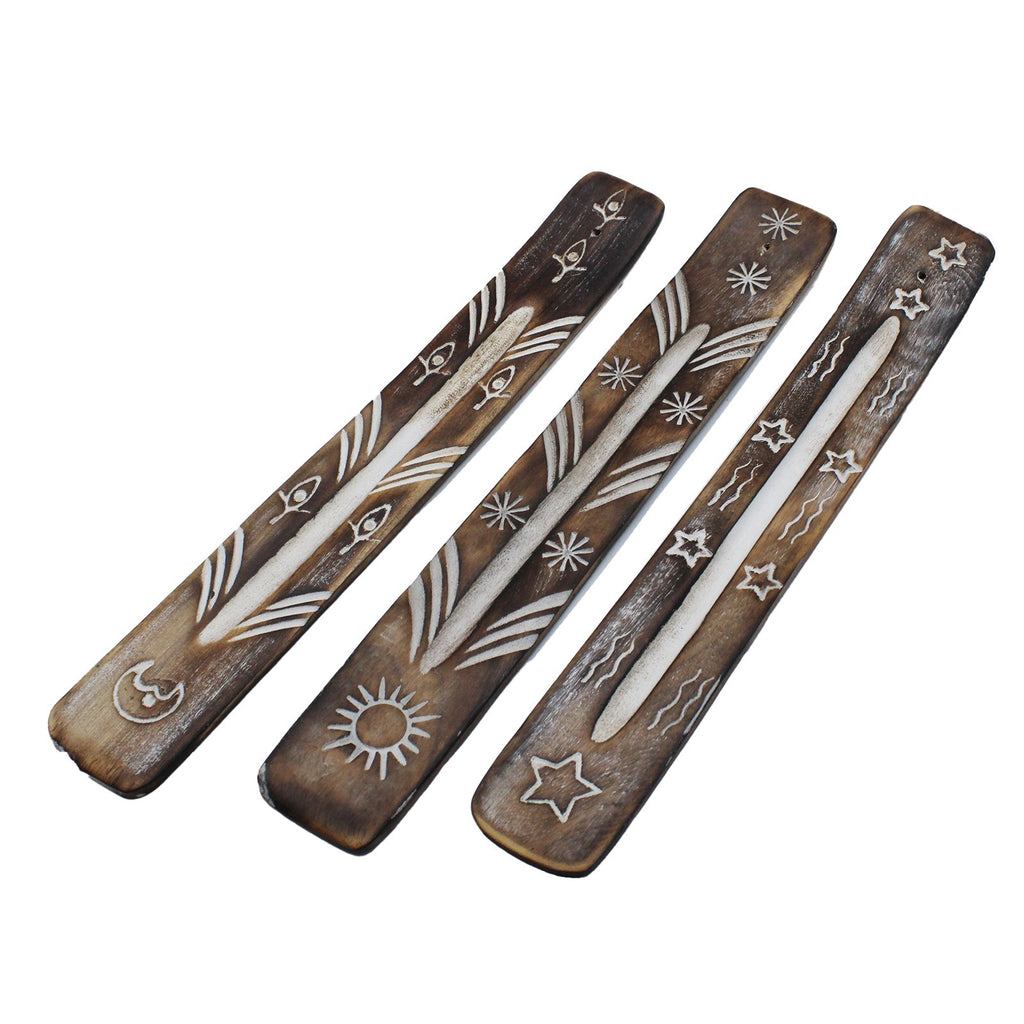 Three wooden incense sticks with decorative patterns on a white background