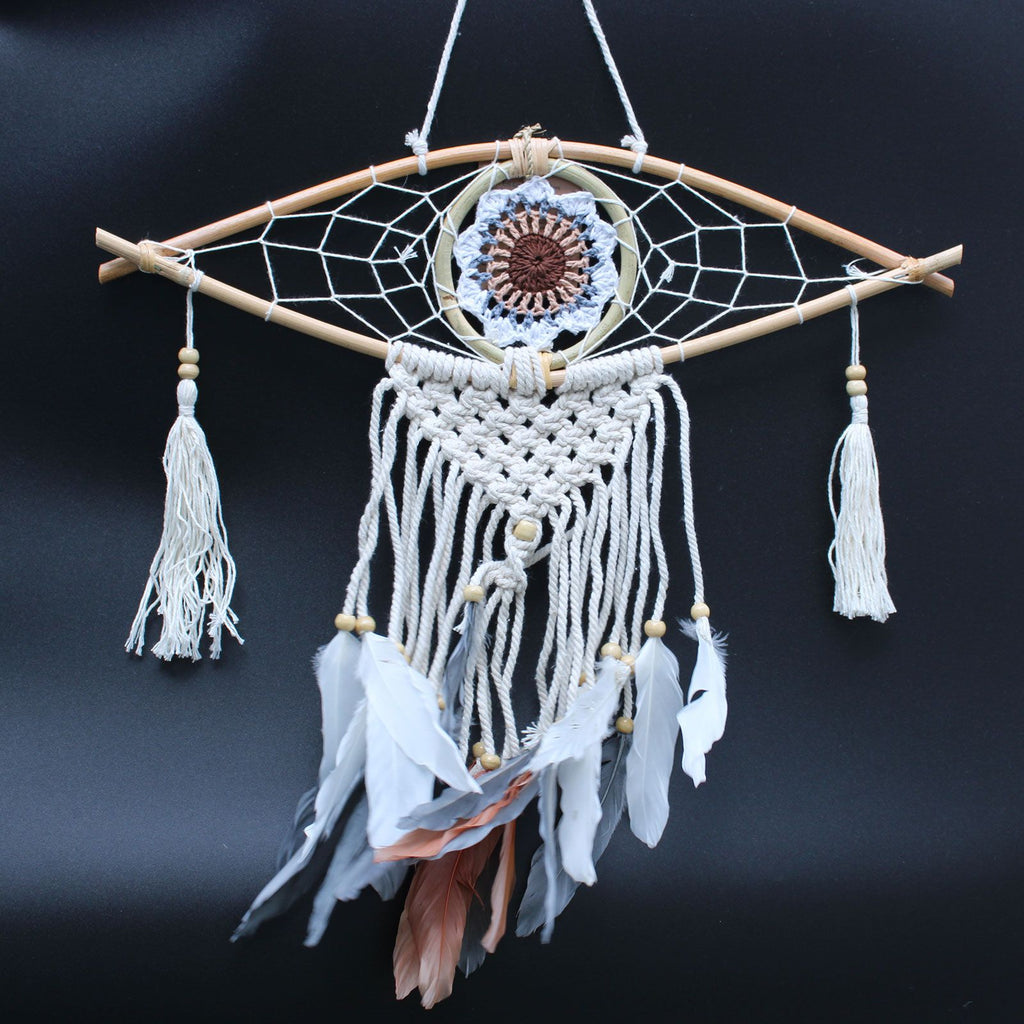 Dreamcatcher with feathers and beads on a dark background